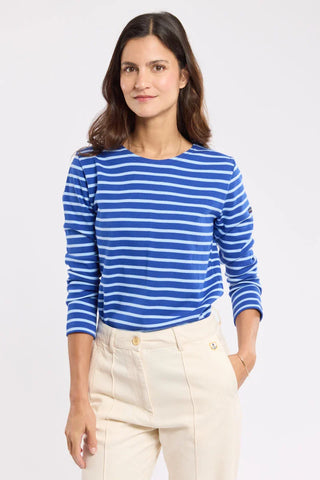 Woman wearing a blue and white striped long sleeve shirt and beige high-waisted pants