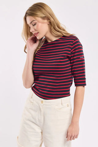 Woman wearing navy and red striped short sleeve top with ivory high-waisted pants