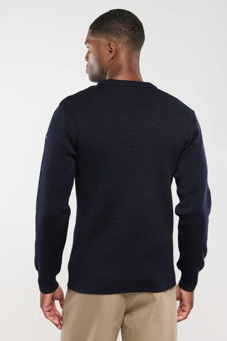 Man wearing a navy blue knit sweater and beige pants, back view, casual fashion