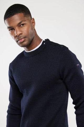 Man wearing a navy blue crew neck sweater with shoulder buttons, casual men's fashion