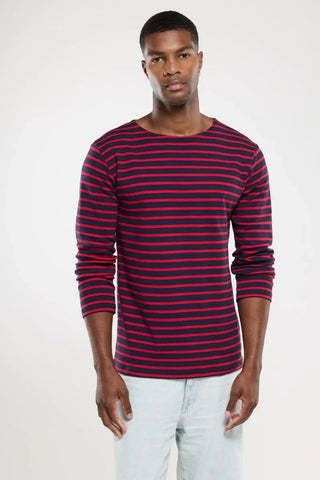 Man wearing navy and red striped long sleeve shirt with light blue jeans, fashion apparel