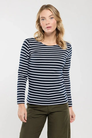 Woman wearing navy and white striped long sleeve shirt and olive pants