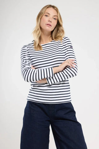 Woman wearing a white and navy striped long sleeve shirt with dark pants