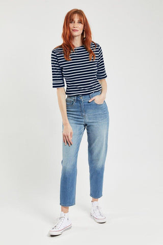 Woman wearing navy and white striped Breton top with 3/4 sleeves and light blue jeans