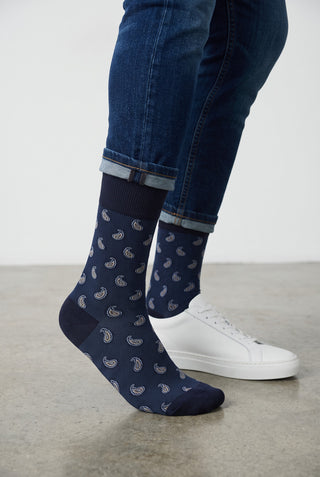 Bas Bugatchi bleu marine en coton et cachemire avec motif paisley, portés avec un jean et des baskets blanches.