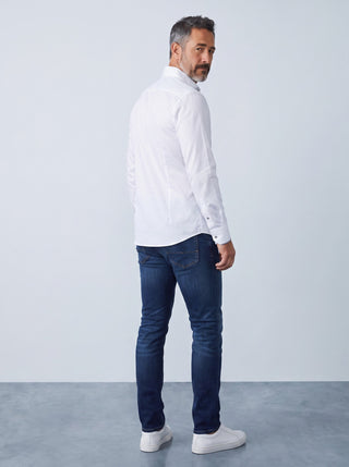 Homme portant une chemise blanche Emanuel Berg Byron en maille extensible avec un jean bleu, vue de dos