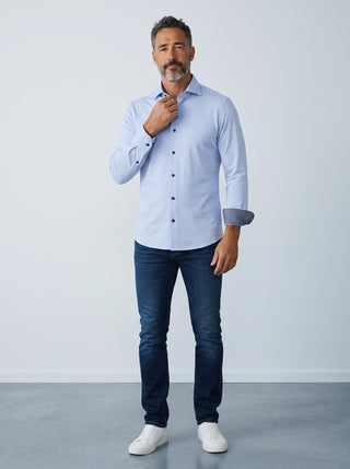 Homme portant une chemise bleue Emanuel Berg Byron en maille extensible avec un jean et des baskets blanches