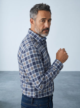 Homme portant une chemise à carreaux bleue Emanuel Berg en maille extensible 4Flex avec col Byron, vue de profil.