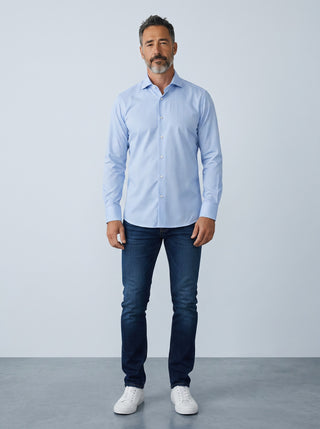 Homme portant une chemise Emanuel Berg Byron bleu clair en maille extensible avec un jean et des baskets blanches