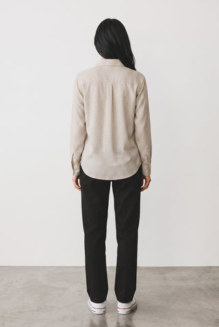 Vue de dos d'une blouse à chevrons beige en viscose par Le Capitaine D'a Bord, portée avec un pantalon noir