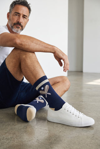 Le Capitaine D'a Bord PULLIN mid-calf navy blue cotton socks with embroidered padel racket motif on a seated man