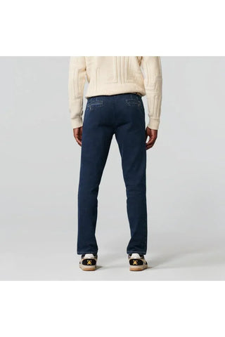 Man wearing dark blue Meyer jeans and cream sweater, rear view, on light background