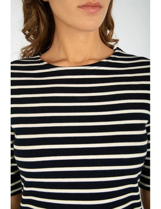 Woman wearing a navy and white striped Breton shirt with three-quarter sleeves
