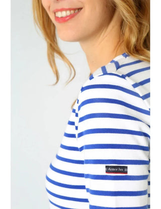 Woman wearing blue and white striped marinière Breton shirt with Armor Lux logo on sleeve