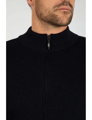 Close-up of man wearing dark wool zip-up cardigan with ribbed collar