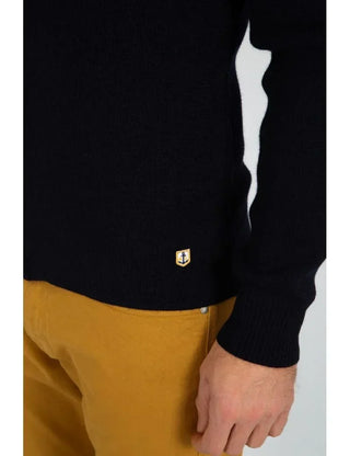 Navy wool cardigan with anchor patch and mustard pants, close-up on waist and sleeve.