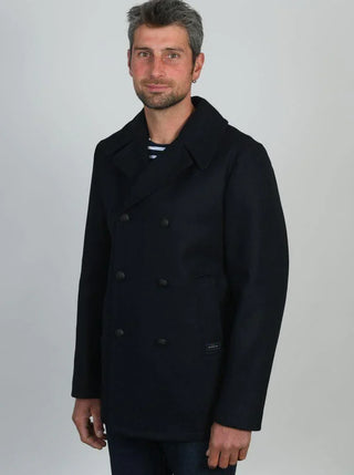 Man wearing a navy wool pea coat with double-breasted buttons and wide collar