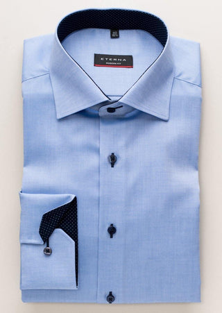 Folded light blue modern fit men's dress shirt with contrasting dark dotted inner collar and cuffs