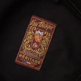 Vrai Basque embroidered label on black wool beret, displays crest and heritage details.
