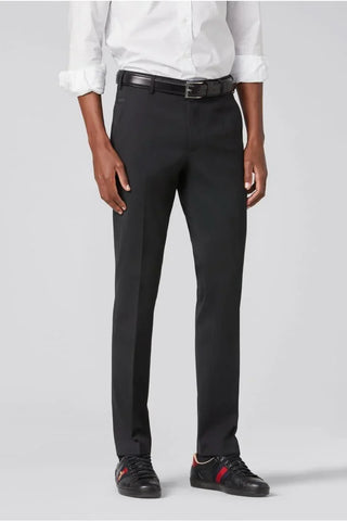 Man wearing black wool dress pants, white shirt, black belt, and black sneakers