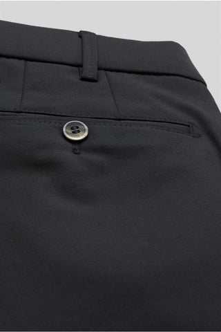 Close-up of dark wool dress pants with buttoned back pocket and belt loop