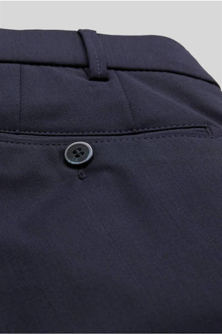 Close-up of navy wool trousers back pocket with button detail and belt loop.