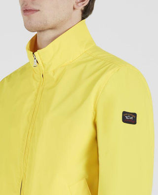 Man wearing yellow nylon zip-up Typhoon 20000 jacket with logo patch on sleeve