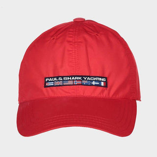 Red nylon yachting cap with 'Paul & Shark Yachting' text and flag patches on the front