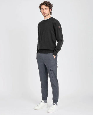 Man wearing black crew neck sweater with shoulder patches and grey cargo pants