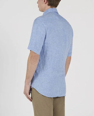 Man wearing light blue linen short-sleeve shirt and beige pants, back view
