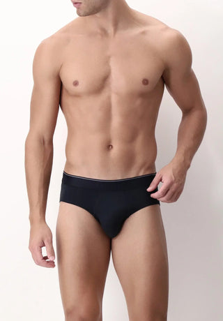 Male model in black briefs underwear, posing against a neutral background